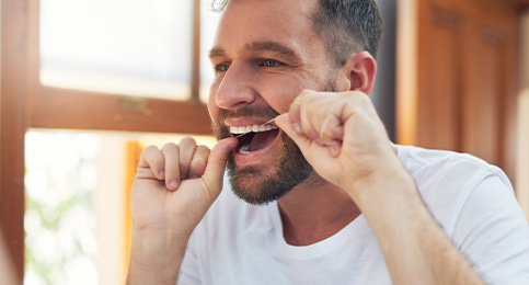 Closeup of man smiling while flossing
