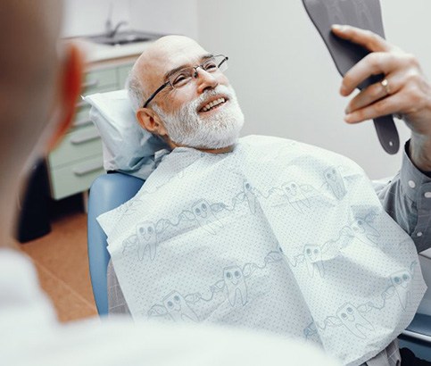 Patient looking at his teeth in mirror